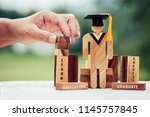 Back to School Concept, Student Sign wood with Graduation celebrating cap on wooden square blocks tower blur hands. Space for letter e.g education, graduate, learn. Ideas for international Educational