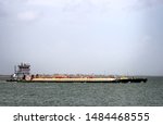 Small photo of Galveston, TX, US - Aug 19, 2019: The F Logan tow boat pushes the Smitty 18 barge into the Galveston channel in Galveston Bay Texas.