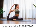 Small photo of Asian woman in sports clothing doing yoga at home to quarantine herself from Covid-19, New normal lifestyle concept. Healthy lifestyle. Relaxing at home