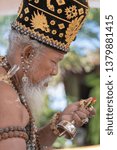 Small photo of UBUD, BALI, INDONESIA - APRIL 22, 2019 : Ida Pedanda Gede Made Gunung a Hindu high priest, conducts religious prayer during Bade cremation ceremony on central street in Ubud, Island Bali, Indonesia