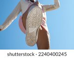 Bottom view of shoe sole, Bottom view boot sole of woman jumping with a blue sky background. Bottom view of woman jumping over the camera and close-up of the sole of the boot