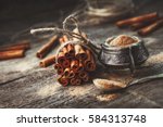 Ground cinnamon, cinnamon sticks, tied with jute rope on old wooden background in rustic style