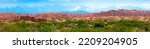 Small photo of Natural unusual landscape of red rocks against the backdrop of blue mountains. The extraordinary beauty of nature is similar to the Martian landscape. Amazingly beautiful landscape. long banner