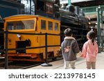 Two kids watching a locomotive moving on the rail