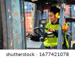 Female Worker Driving Forklift...
