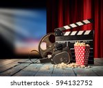 Retro film production accessories placed on wooden planks. Concept of film-making. Red curtain and movie screen on background