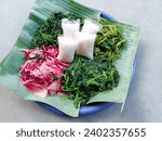 Small photo of pecel or traditional Indonesian food contains boiled torch ginger (Etlingera Elatior), boiled spinach, boiled kenikir plant (cosmos caudatus), boiled water spinach and rice cake. vegetable salad
