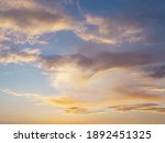 Small photo of Clouds illuminated by sunset sunlight in the blue sky. Background texture. Fullscreen photo