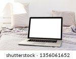 The laptop and computer in the morning on a white pillow bed. Lifestyle Concept