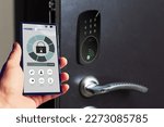 Locking smartlock on the entrance door using a smart phone remotely. Concept of using smart electronic locks with keyless access