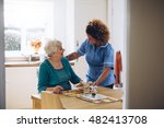 Care Worker Giving An Old Lady...