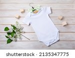White cotton baby short sleeve onesie mockup with white lilac and children toy blocks. Design gender neutral bodysuit template, newborn romper print presentation mock up
