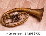 Small photo of old rusty alto saxhorn on wooden background.