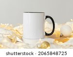 Festive Christmas background White ceramic tea mug with black handle and copy space for your imprint. Front view 11oz cup background for Christmas promotional content or branding