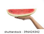 Hand holding piece of watermelon. 