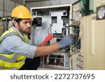 Small photo of Male electrician worker checking, repair, maintenance operation electric system in factory. Male electrician using electrical meters working with operation electric system in workshop