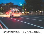  Defocused photo of  ambulance car on the street , blurred image of emergency car running on the road at the evening