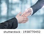 Small photo of Businessmen reach out to each other to shake hands on a blurred background.