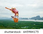 Lifestyle image of happy young traveling woman jumping carefree on nature background. In the mountains. Wearing stylish short shorts and checkered shirt. Freedom and happiness concept. In motion