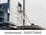 Small photo of facade installation, men at work, workers install, on a high-rise building. Installation in an office on a construction site. curtain wall systems are new, panel, frame, multilayer, construction.