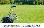 Small photo of Golf clubs in a golf bag isolated. Set of golf clubs for a golfer. Copy Space. green Background. Close-up. High quality photo