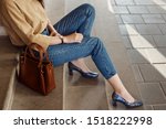 Street style, fashion trends concept: crop of fashionable woman`s outfit. Lady wearing casual clothes, python print, textured shoes with square toe, block heels. Copy, empty space for text