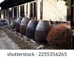 Large ceramic indigo barrel jars in front of a traditional atelier of the famous Japanese Aizome dye. Indigo is a method of natural textile dyeing that achieves deep blue colors.