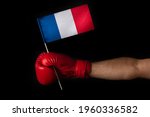 Boxer hand holds flag of French. Boxing glove with the French flag. Black background