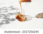 Small photo of Pouring Cold Drink on ice in the Sun. Cold brew Ice Summer. Summertime drink. Sunny Day Drink. Cold Tea. Iced Tea. Cold Coffee. Ice Coffee