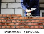 professional construction worker laying bricks and building house on industrial site.