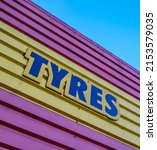 Small photo of Garish Sign For Tyres (Tires) At A Garage Or Service Station