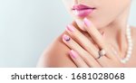 Small photo of Nail art and design. Beautiful woman wearing make-up and pearl jewellery showing pink manicure with gems. Beauty fashion model. Skin care. Banner