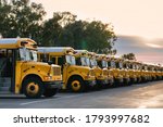 Row of school buses in parking...