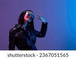 Small photo of Friendly pretty awesome brunet woman in leather jacket trendy specular sunglasses greet someone posing isolated in blue violet color light background. Neon party Cyberpunk concept. Copy space