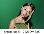 Green Summer Beauty: Young Caucasian Woman with Attractive Portrait and Fresh Makeup, Surrounded by Tropical Leaves in a Exotic Park