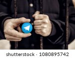 Man holding sign of blue coin depicting white airplane ICO Gram. Concept Telegram messenger is banned. Roskomnadzor blocked Telegram service