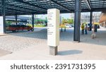 Small photo of Jakarta Nov 01 2023: Directional totem pylon sign in beige color near a steel roof outdoor structure at Indonesia Design District PIK 2 an outdoor strip mall