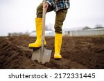 Female worker digs soil with...