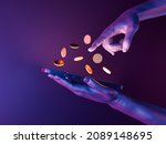 3d hands holding a cell phone with coins on the screen. neon lights. futuristic concept of play to earn, video games, technology, metaverse and crypto. 3d rendering