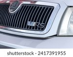 Small photo of Bristol , UK - November 11, 2023: ''RS'' sometimes encoded as ''VRS'' signage on the front grille of the Skoda. Chrome and Black. Framed in black glossy frame. Gray car
