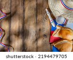 Chilean independence day concept. fiestas patrias. Tipical baked empanadas, wine or chicha, fat and play emboque. Decoration for 18 september party day, wooden background, top view.