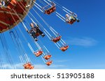 Mother with the six-year-old son ride an attraction on a swing agains the blue sky in amusement park