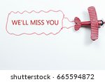 writing We'll Miss You red toy airplane with talk bubble on white background