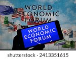Small photo of The World Economic Forum (WEF) logo is displayed on a smart phone, with The World Economic Forum seen in the background, in this photo illustration. On 14 January 2024 in Brussels, Belgium.