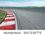 Wide angle close up empty cornering asphalt modern circuit road and blue cloud sky background.