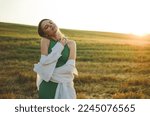 Beautiful woman in a green dress. Photo of a girl in a field at sunset. Atmospheric photo in a field in sunlight.Blonde with short hair.sensual photo of a girl.delicate portrait.sunset portrait.