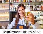 Young Woman Serving Draft Beer. ...