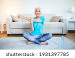 Small photo of Senior woman doing warmup workout at home. Fitness woman doing stretch exercise stretching her arms - tricep and shoulders stretch . Elderly woman living an active lifestyle.