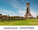 Small photo of Muscat, Oman - May 26, 2022: View of the clock tower of Sultan Qaboos University with the backdrop of Date tree orchard.