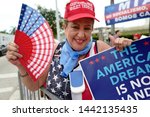 Small photo of Miami, Florida/USA-June 26, 2019: Roxanna Greene, an activist and supporter of President Donald Trump, protests outside a Democratic presidential debate, waving American flags and political messages